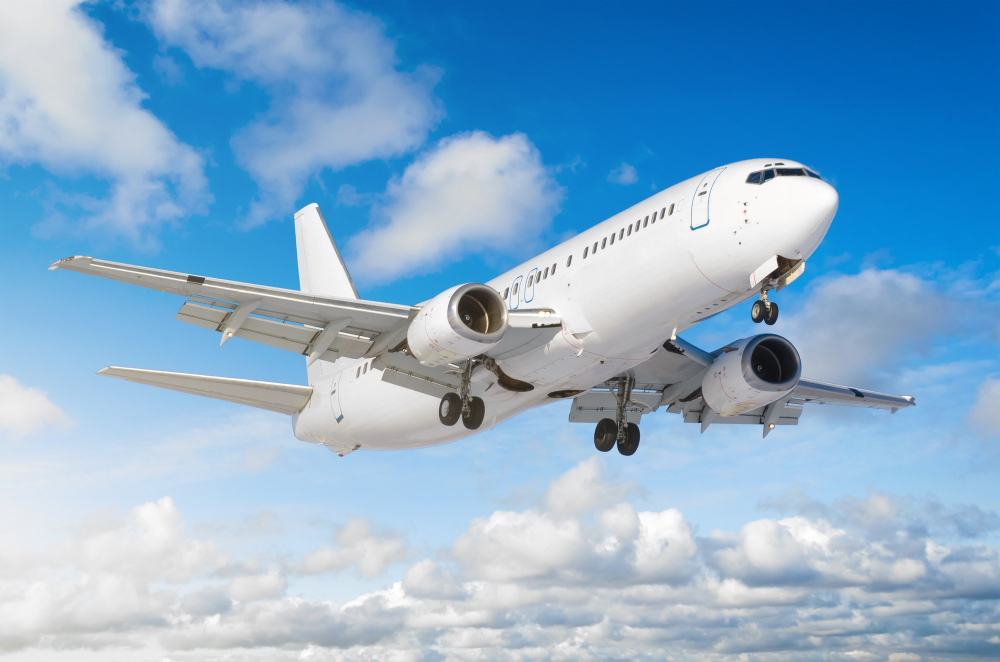 Airplane flying in blue sky with clouds